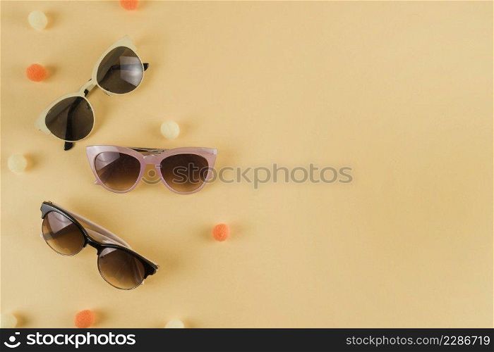 different types sunglasses with pom pom beige backdrop