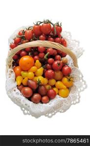 Different varieties of tomatoes in a basket on a white background