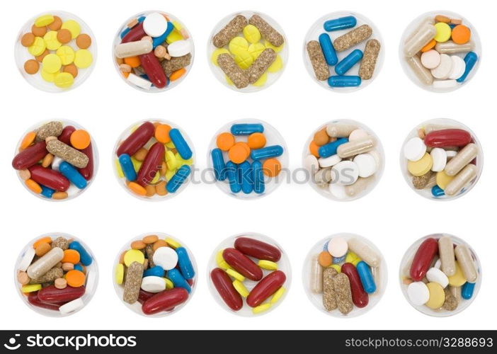 differently colored and shaped pills on white background