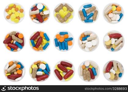 differently colored and shaped pills on white background