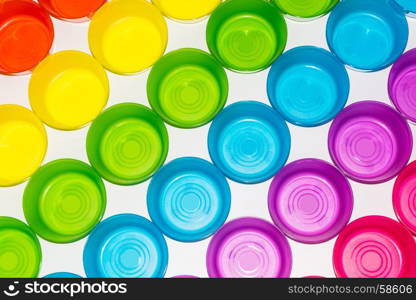 Differently colored colorful glasses on a white background. Taken from above.