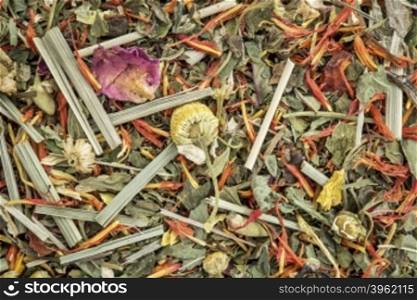 digestion and bloating herbal tea with peppermint, spearmint, honeybush, hibiscus. osmanthus, chamomile. lemon grass, saffron, ginger, lemon balm - closeup background
