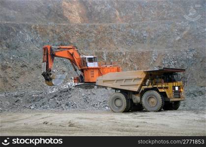 Digger loading up trucks with rock at Stockton Coal Mine, Westland, New Zealand