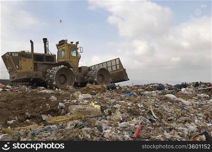 Digger working at landfill site