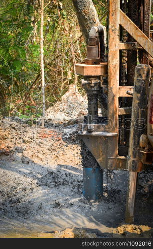 Digging hole drilling groundwater machine installed on deeps ground soil and mud