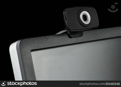 Digital black computer monitor screen and HD web camera on black background