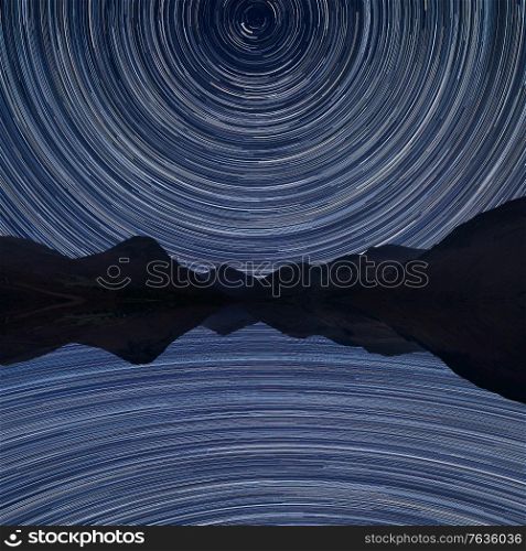 Digital composite image of star trails around Polaris with Stunning landscape of mountains in Lake District