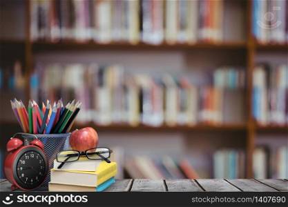 digital composite of School materials and apple with library background