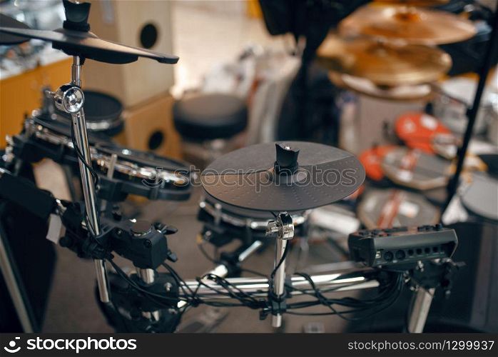Digital drum set on showcase in music store, closeup view, nobody. Assortment in musical instrument shop, professional equipment for musicians and performers. Digital drum set in music store, nobody