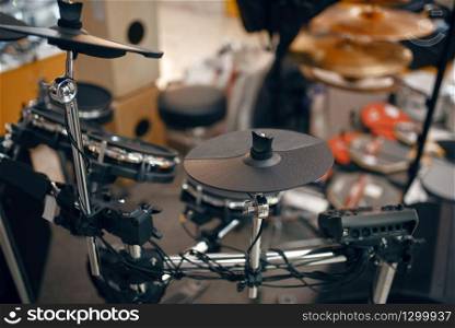 Digital drum set on showcase in music store, closeup view, nobody. Assortment in musical instrument shop, professional equipment for musicians and performers. Digital drum set in music store, nobody