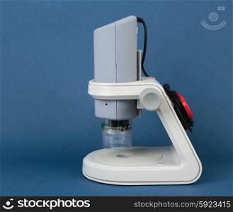 Digital educational microscope on blue background