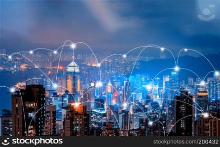 Digital network connection lines of Hong Kong Downtown and Victoria Harbour. Financial district in smart city in technology concept. Skyscraper and high-rise buildings. Aerial view at night.