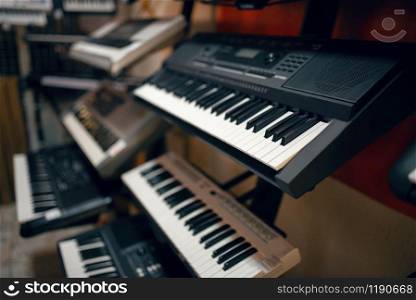 Digital synthesizers on showcase in music store, closeup view, nobody. Assortment in musical instrument shop, professional equipment for musicians and performers