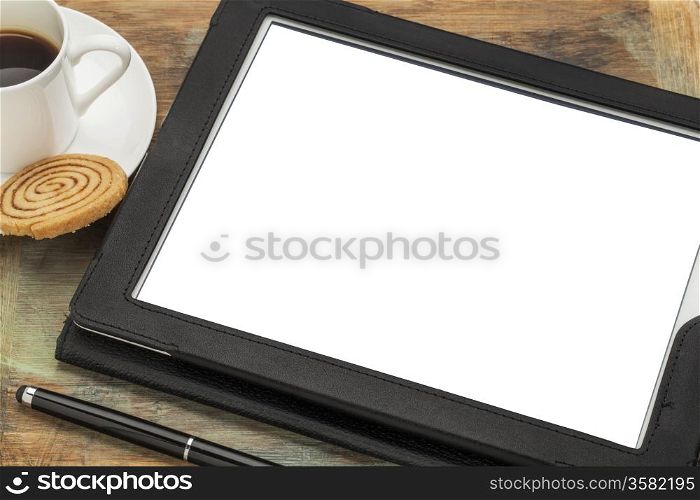 digital tablet computer in black leather case with white blank screen isolated with clipping path, stylus pen, coffee cup and cookie