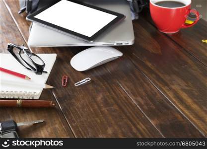 digital tablet, laptop computer and notebook on wooden office desk
