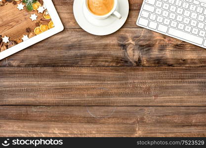 Digital tablet pc, keyboard and cup of coffee on wooden table. Christmas cookies. Vintage style toned picture