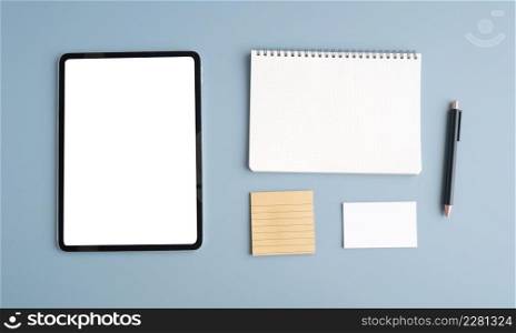 Digital tablet with blank on screen , note papers and pen isolated on gray background, for template, mock up, topview, flat lay, communication technology