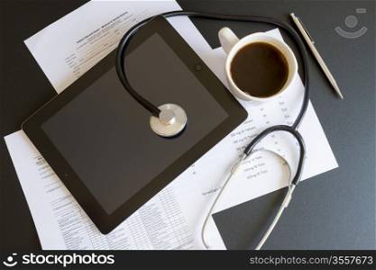 Digital tablet with stethoscope and paperwork