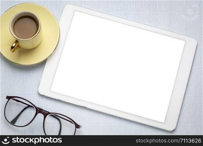 digital tablet with white blank screen, cup of coffee, reading glasses - flat lay concept