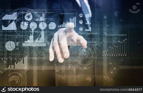 Digital technlogies in use. Close up of businessman touching virtual panel with finger