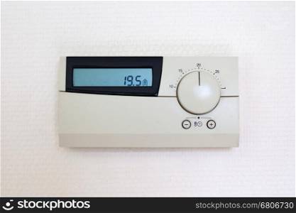 Digital Thermostat set to 19,5 degrees Celsius, isolated on white wall