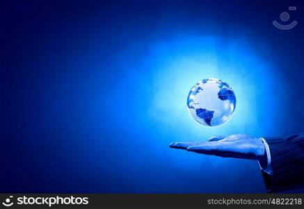 Digital world. Person hand and digital Earth planet on palm on blue background