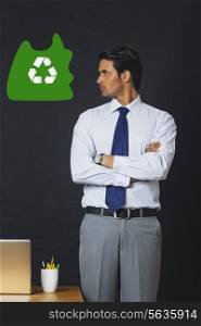 Digitally generated image of businessman looking at recycling symbol in office