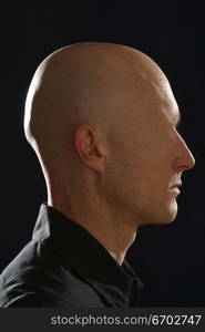 Digitally manipulated image of a bald man&acute;s profile. Faceless. All skin. Horror theme.