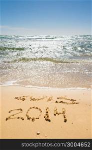 digits 2013 and 2014 on the sand seashore - concept of new year and passing of time