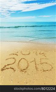 digits 2014 and 2015 on the seashore sand - concept of new year and passing of time