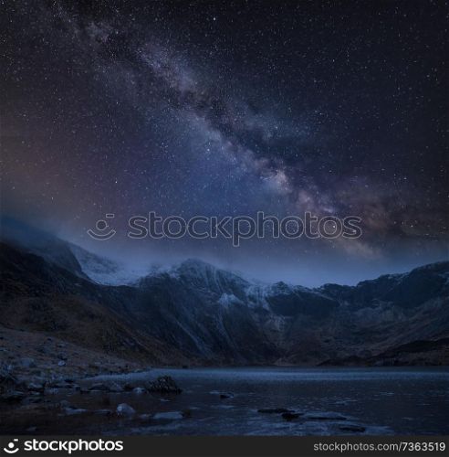 Digtial composite image of Winter landscape of snowcapped Mountain Range at night with Milky Way above