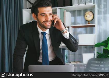 Diligent businessman busy talking on the phone call with clients while working with laptop in his office as concept of modern hardworking office worker lifestyle with mobile phone. Fervent. Businessman making a sales call with clients at office. fervent