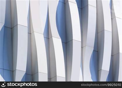 Dimension curve lines of white and gray aluminium composite tile wall decoration of modern building with sunlight and shadow on surface, Geometric exterior architecture background in minimal style