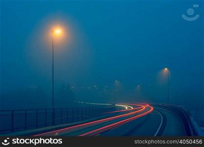 Diminishing perspective of light trails on misty road illuminated by street lights, Haugesund, Rogaland County, Norway