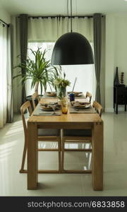 dining table and comfortable chairs in modern home with elegant table setting