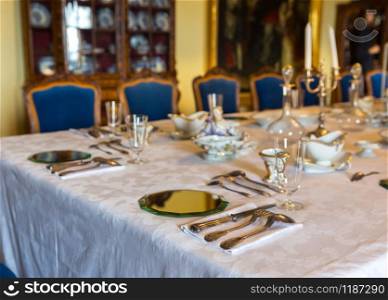 Dining table with dishes, Europe museum, nobody. Old european architecture and style, famous places for travel and tourism. Dining table with dishes, Europe museum, nobody