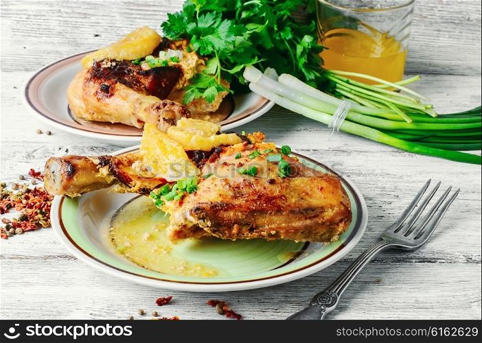 Dinner of baked chicken thighs in orange with spices. drumstick on porcelain plate