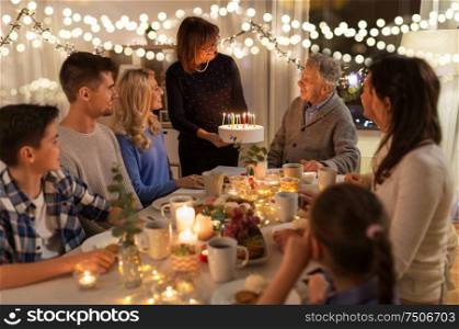 dinner party and celebration concept - happy family with cake celebrating grandfathers birthday at home. happy family having birthday party at home