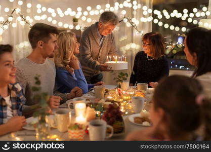 dinner party and celebration concept - happy family with cake celebrating grandmothers birthday at home. happy family having birthday party at home