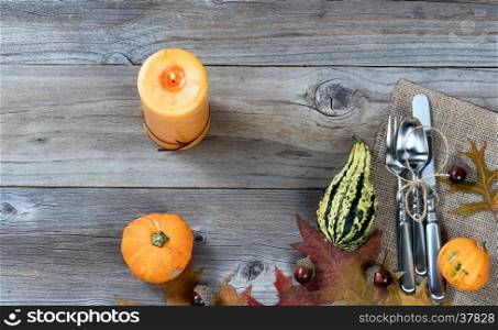 Dinner place setting for Thanksgiving Autumn holiday in horizontal layout on rustic wooden boards.
