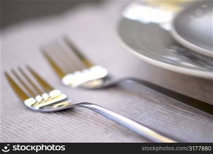 Dinner place setting with plates and cutlery shallow dof
