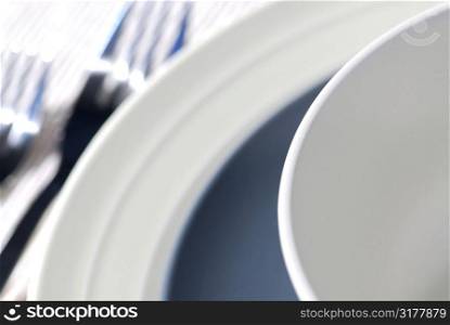 Dinner place setting with plates cutlery and soup bowl shallow dof