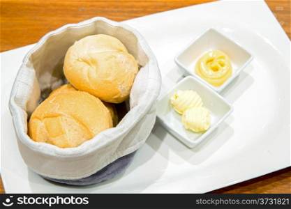Dinner rolls with butter in white dish