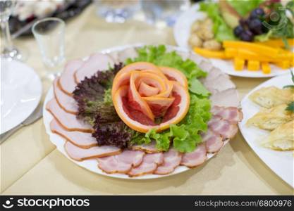 Dinning table set with baked sliced ham, garnished with salad