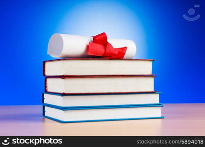 Diploma and stack of books against the background