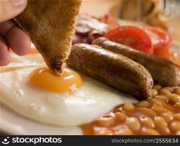 Dipping Toast into a Fried Egg on a Full English Breakfast