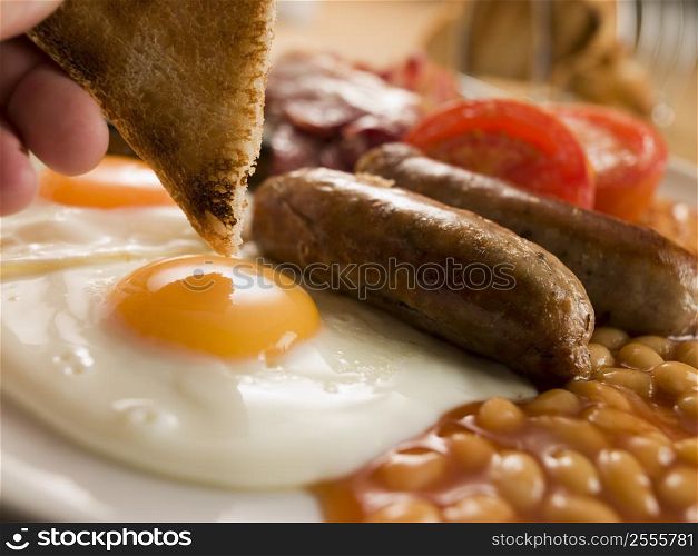 Dipping Toast into a Fried Egg on a Full English Breakfast