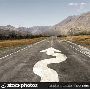 Direction sign on road. Natural landscape of asphalt road and drawn twisting arrow