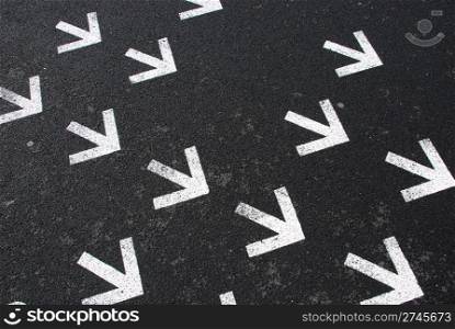 directional white arrow signs on the asphalt road
