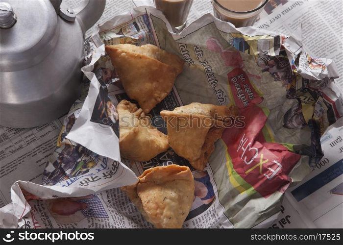 Directly above shot of fresh samosas and tea kettle on table